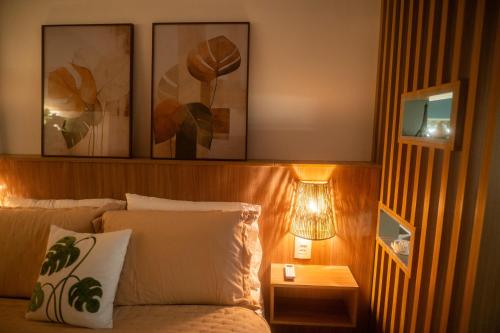 a bedroom with a bed with two pictures on the wall at Aurora Studio no Centro in Barbacena