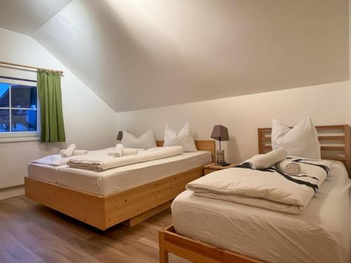 two twin beds in a room with a window at Sauna Chalet Ahorn in Bad Kleinkirchheim