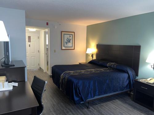 a hotel room with a bed and a table and a desk at Anastasia Inn - Saint Augustine in St. Augustine