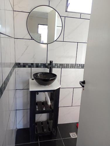 a bathroom with a sink and a mirror at Cabañas La Puesta del Sol in Estancia Vieja