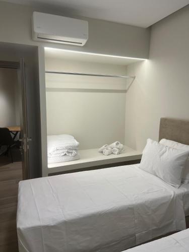 ein Schlafzimmer mit einem weißen Bett und einer Klimaanlage in der Unterkunft GreDa in Malia