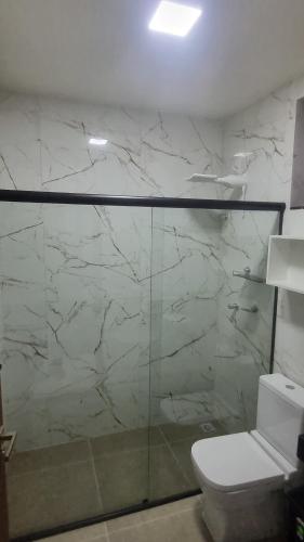 a bathroom with a toilet and a glass shower at Apartamento completo 2 quartos in Brasília
