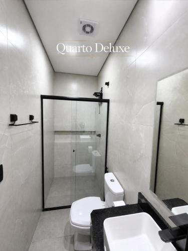 a bathroom with a shower and a toilet and a sink at Hotel Serra do Mar in Paranaguá