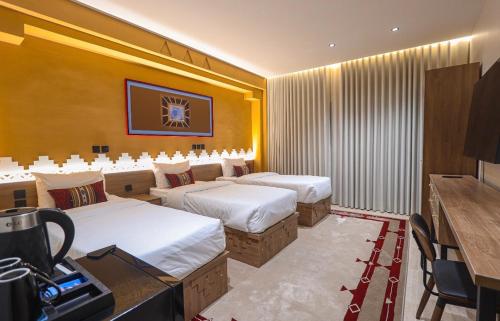 a hotel room with two beds and a desk at نخله للوحدات السكنية 2 in Medina