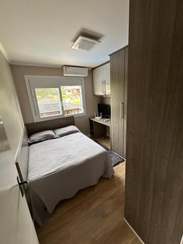 a small bedroom with a bed and a window at Casa Garavaglia in Bento Gonçalves