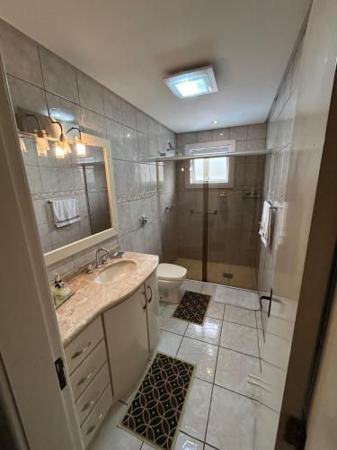 a bathroom with a sink and a shower and a toilet at Casa Garavaglia in Bento Gonçalves