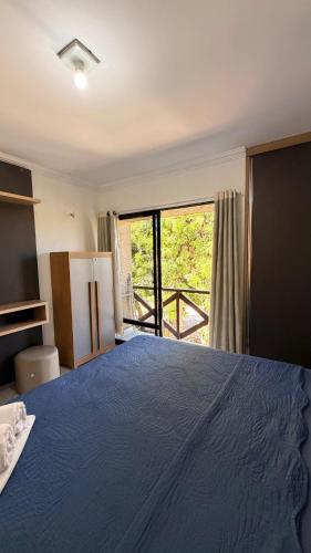 a bedroom with a large blue bed with a window at 204 Eco Paradise Cumbuco in Caucaia
