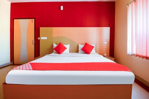 a red bedroom with a large bed with red pillows at Hotel Samar Palace Near Sodala Vivek Vihar Metro Station in Jaipur