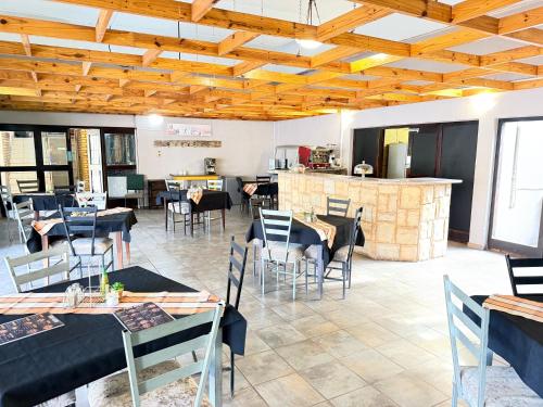 a restaurant with tables and chairs and a kitchen at Postmasburg hotel in Postmasburg