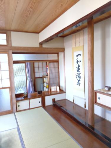 a room with wooden floors and windows and a rug at ただいまtadaima in Yahata