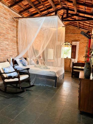 a bedroom with a bed with a mosquito net at Refúgio mar aberto BA in Alcobaça