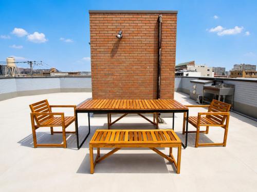 a bench and two chairs on top of a roof at Tokyo Grand House in Akishima
