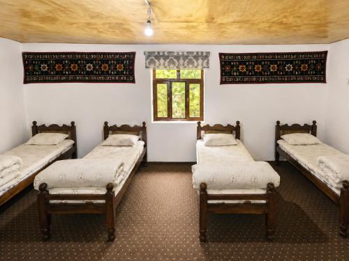 a room with three beds and a window at Muso guesthouse in Yukary-Ukhum