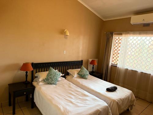 a bedroom with two beds and a window at Postmasburg hotel in Postmasburg