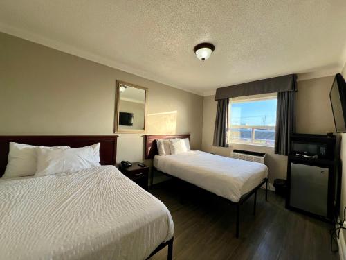 a hotel room with two beds and a window at London Residency Inn in London