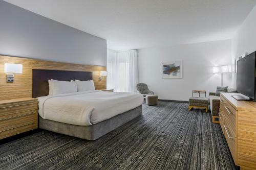 a hotel room with a bed and a flat screen tv at TownePlace Suites by Marriott Boynton Beach in Boynton Beach