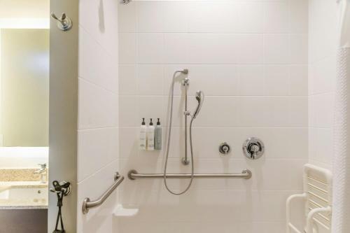 a shower in a bathroom with white tiles at TownePlace Suites by Marriott Boynton Beach in Boynton Beach