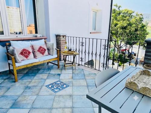 a balcony with a bench and a table at DomoMea Rooms in Loculi