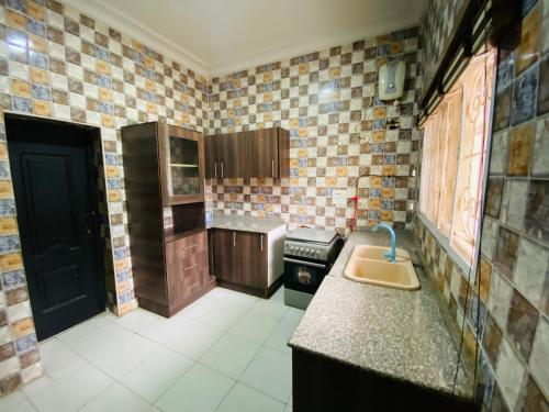 a small kitchen with a sink and a counter at Crispan Luxury Apartment in Jos