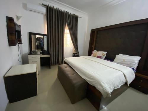 a bedroom with a large bed and a window at Crispan Luxury Apartment in Jos