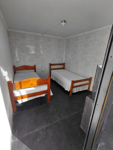 a small room with two beds in it at hostal y centro de eventos in Chorrillos
