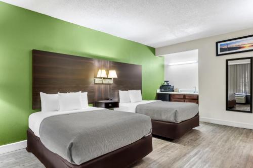 two beds in a room with green walls at Quality Inn & Suites Ridgeland in Ridgeland