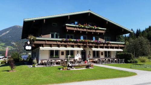 a large building with tables and chairs in front of it at Gasthof Schütthof in Neukirchen am Großvenediger