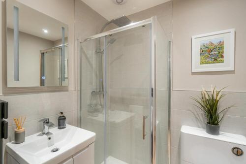 a white bathroom with a shower and a sink at 1 Bed in Grasmere oc-lr068 in Grasmere