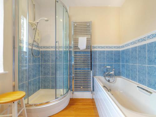 a bathroom with a tub and a glass shower at 4 Bed in Ambleside oc-lr082 in Ambleside
