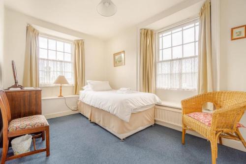 a bedroom with a bed and a chair and windows at 4 Bed in Ambleside oc-lr082 in Ambleside