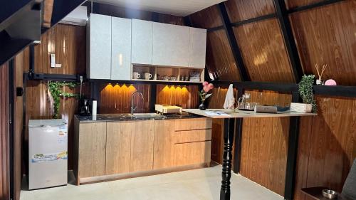 eine Küche mit Holzwänden und einer Theke mit Kühlschrank in der Unterkunft Dar Batroun in Batrun