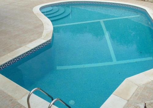 a large swimming pool with blue water at Villa Vau in Portimão