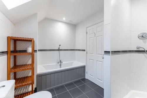 a white bathroom with a tub and a sink at 1 Bed in Skelwith Bridge oc-lr159 in Elterwater