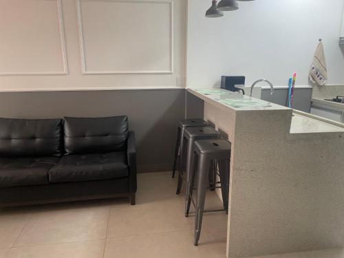 a kitchen with a counter and a couch in a room at Flat Residence Campinas in Campinas