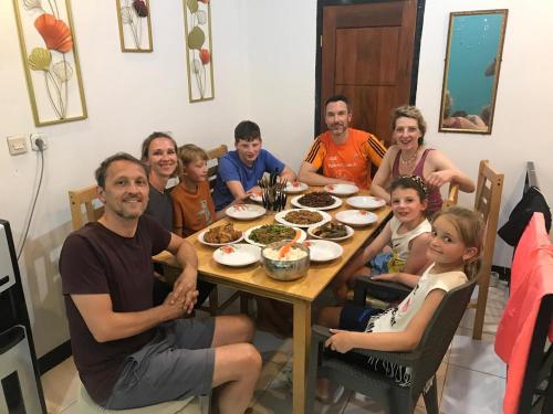 a group of people sitting around a table at Rusde's Komodo Homestay in Pulau Komodo