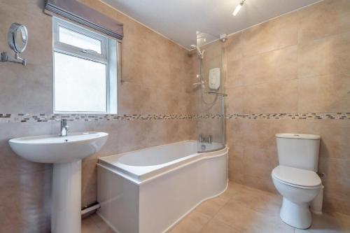 a bathroom with a sink and a toilet and a tub at 2 Bed in Ambleside oc-lr114 in Chapel Stile