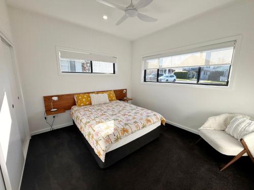 a bedroom with a bed and a window at Loveday on Landsborough in South West Rocks