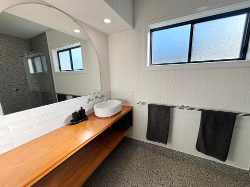 a bathroom with a sink and a mirror at Loveday on Landsborough in South West Rocks