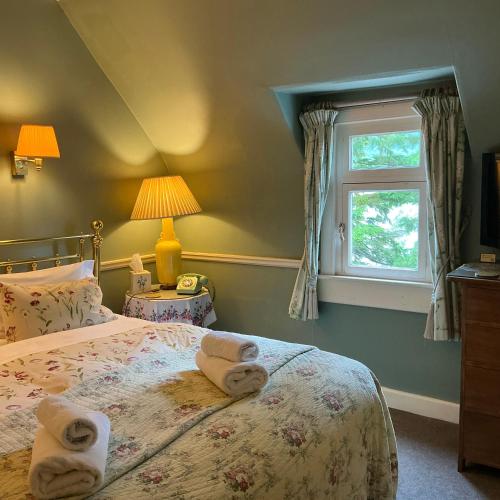 a bedroom with a bed with towels on it at Corriegour Lodge Hotel in Spean Bridge