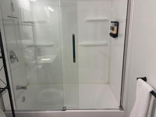 a shower with a glass door in a bathroom at AYBAM's House in Winnipeg