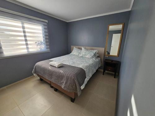 a bedroom with a bed and a window and a mirror at Hostal HDQ en Concepción Sector Collao in Concepción