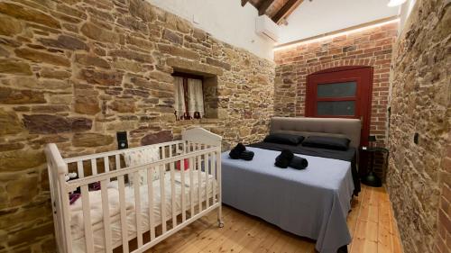 a bedroom with a crib and a stone wall at Archontiko Chios Traditional Mansion in Thymianá