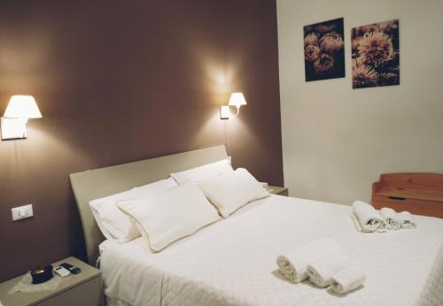 a bedroom with a bed with two slippers on it at Nonno Turiddu Elegant Rooms in Caccamo