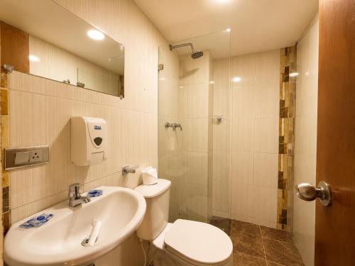 a bathroom with a toilet and a sink and a shower at Hotel Laureles Palo Alto in Medellín
