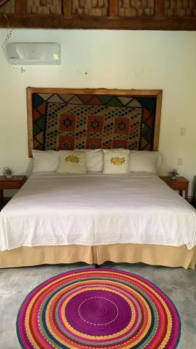 a bedroom with a large bed with a rug on the floor at Villas Boutique Antheia in La Orilla