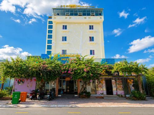 a white building with a tower in the background at Q Song Chi Côn Đảo Hotel in Con Dao