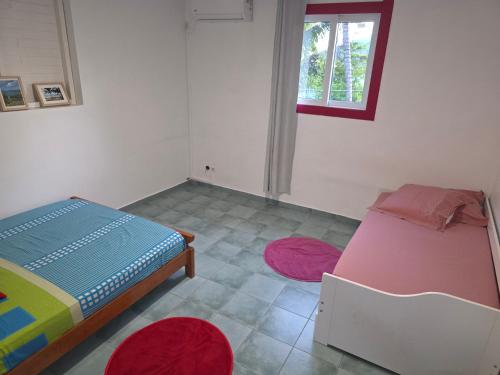 a bedroom with a bed and two rugs at Villa Ti'Sol in Saint-François