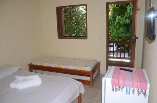 a room with two beds and a window at Hostel Solua - trindade in Paraty