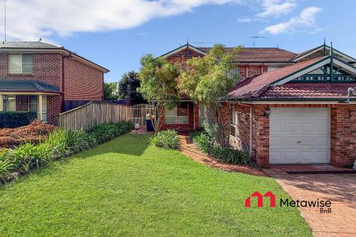 a brick house with a garage and a yard at Spacious 4-Bedroom Home in Cherrybrook in Cherrybrook
