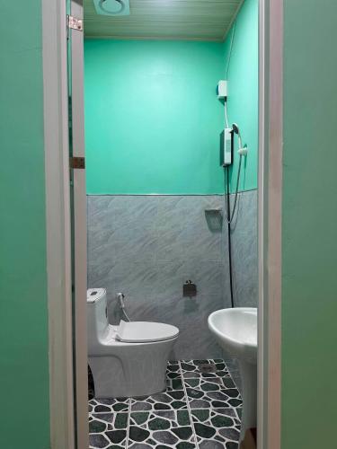 a bathroom with a tub and a toilet and a sink at SunriseStay in Panglao Island